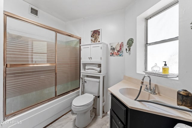 full bathroom with shower / bath combination with glass door, tile flooring, vanity, and toilet