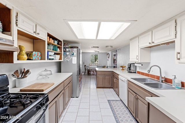 kitchen featuring white cabinetry, gas stove, stainless steel fridge, and light tile floors