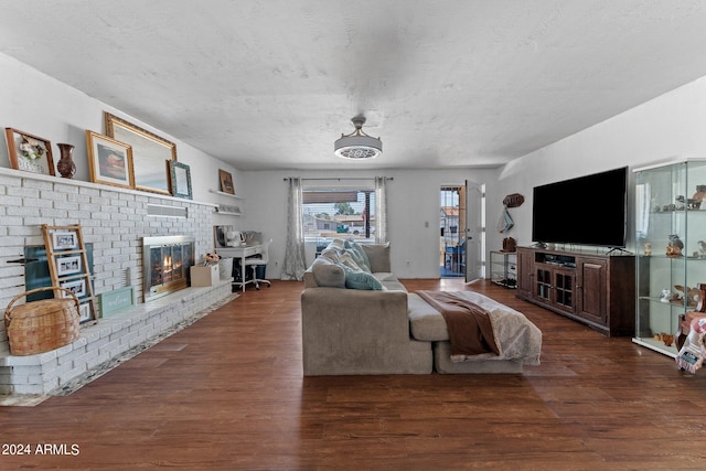 living room with dark hardwood / wood-style flooring and a brick fireplace