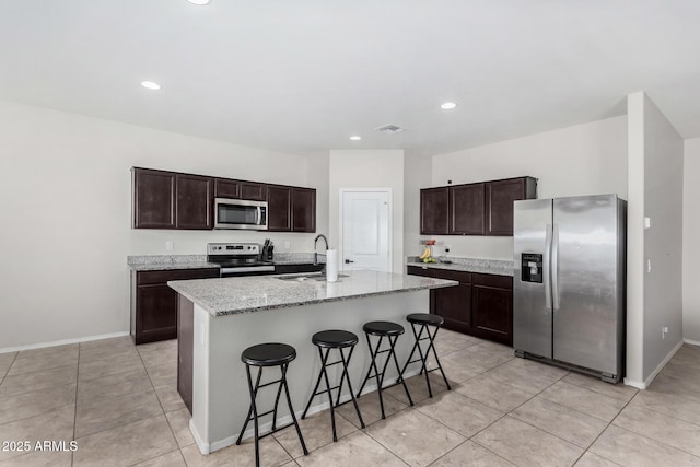 kitchen with stainless steel appliances, dark brown cabinets, a sink, and visible vents