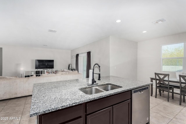 kitchen featuring dark brown cabinets, stainless steel dishwasher, a sink, and visible vents