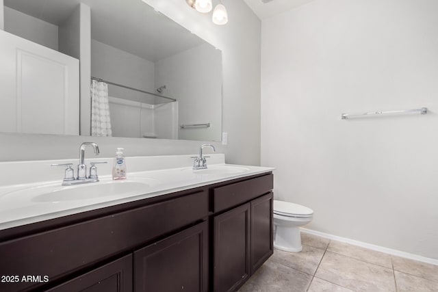 bathroom with double vanity, a sink, toilet, and tile patterned floors