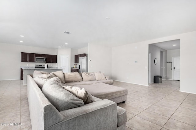 living area with light tile patterned floors, baseboards, and recessed lighting