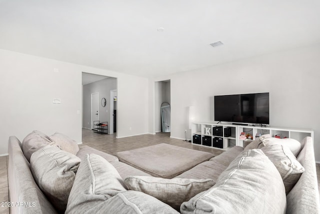 living area featuring visible vents, baseboards, and light tile patterned floors