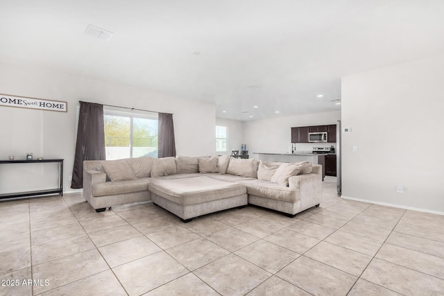 living room featuring light tile patterned floors, baseboards, and recessed lighting