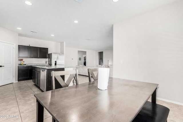 dining room with light tile patterned floors, baseboards, and recessed lighting