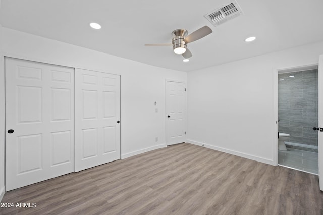 unfurnished bedroom with ceiling fan, a closet, connected bathroom, and light hardwood / wood-style flooring