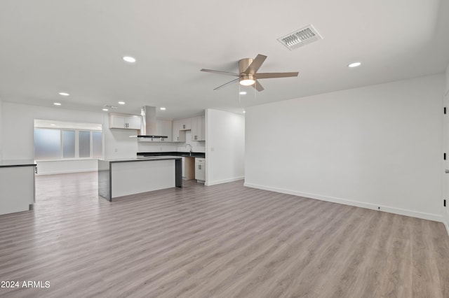 unfurnished living room featuring ceiling fan and light hardwood / wood-style floors