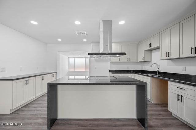 kitchen featuring sink, white cabinetry, and island range hood