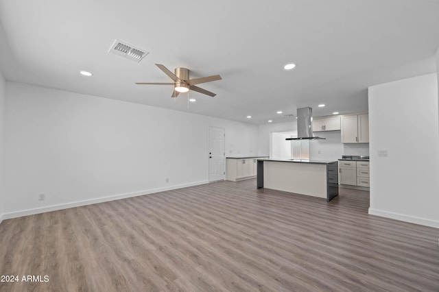 unfurnished living room with ceiling fan and hardwood / wood-style flooring