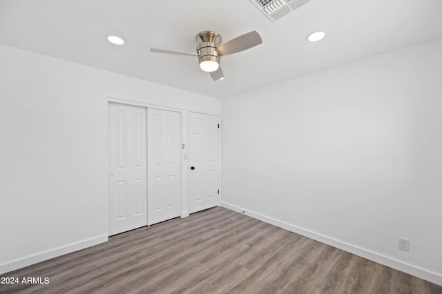 unfurnished bedroom with ceiling fan, a closet, and hardwood / wood-style flooring