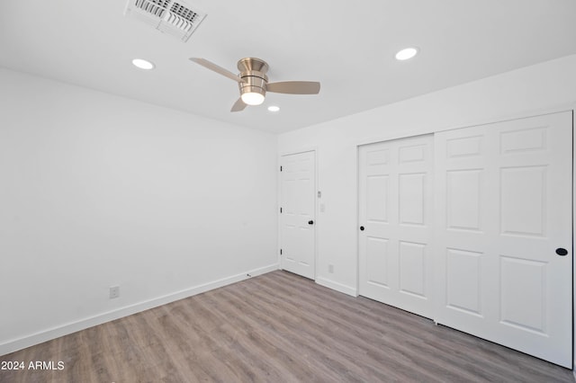 unfurnished bedroom with ceiling fan, a closet, and hardwood / wood-style floors