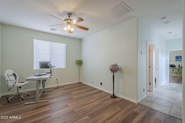 office featuring baseboards, visible vents, wood finished floors, and ceiling fan