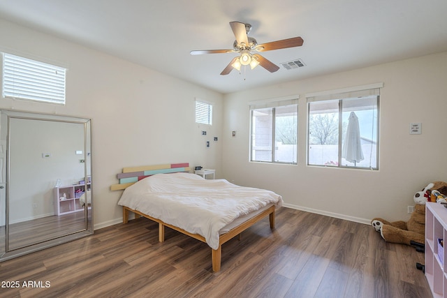 bedroom with baseboards, visible vents, a ceiling fan, and wood finished floors