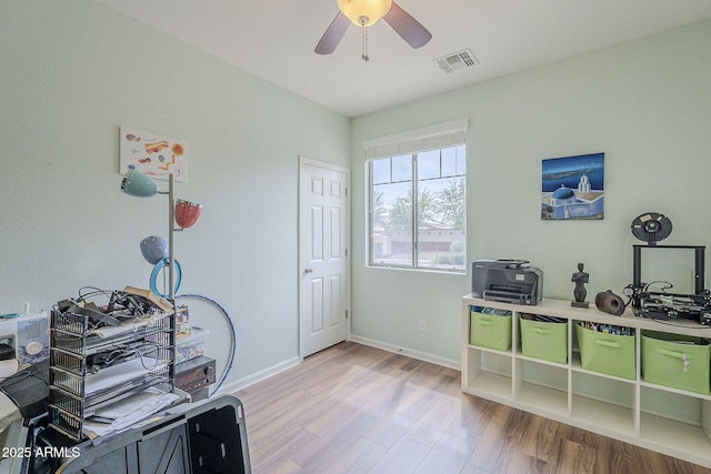 office space with baseboards, visible vents, a ceiling fan, and wood finished floors