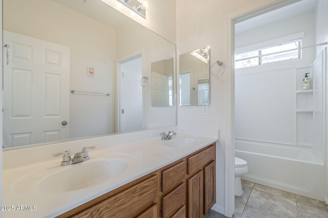 bathroom with toilet, a sink, double vanity, and tile patterned floors