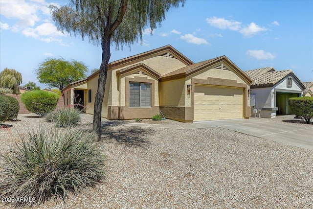 ranch-style house with concrete driveway, an attached garage, and stucco siding