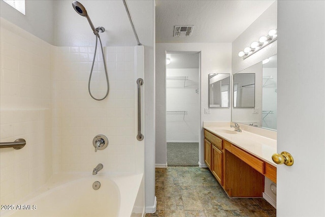 full bath featuring vanity, baseboards, bathing tub / shower combination, a spacious closet, and visible vents