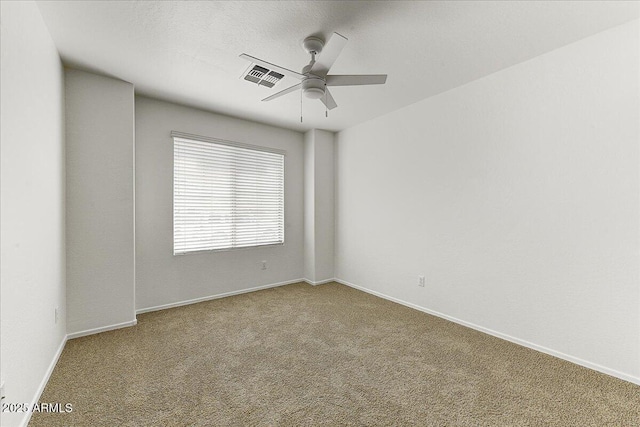 carpeted empty room featuring a ceiling fan, baseboards, and visible vents