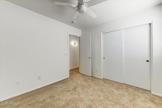 unfurnished bedroom with baseboards, light carpet, ceiling fan, and a closet