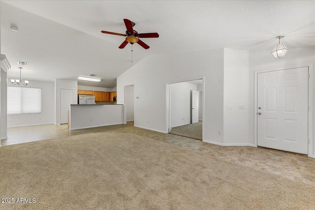 unfurnished living room featuring visible vents, baseboards, light colored carpet, ceiling fan with notable chandelier, and vaulted ceiling