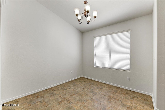 spare room with baseboards and a notable chandelier
