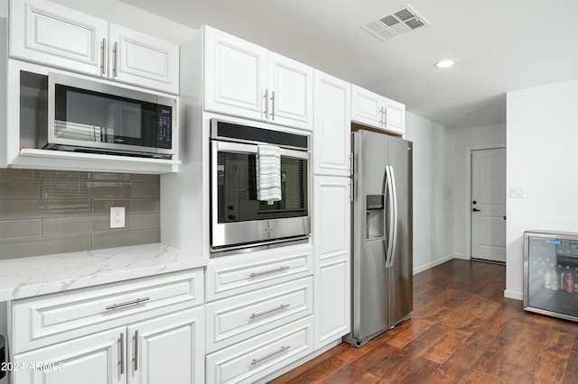 kitchen featuring dark hardwood / wood-style floors, light stone countertops, backsplash, appliances with stainless steel finishes, and white cabinetry