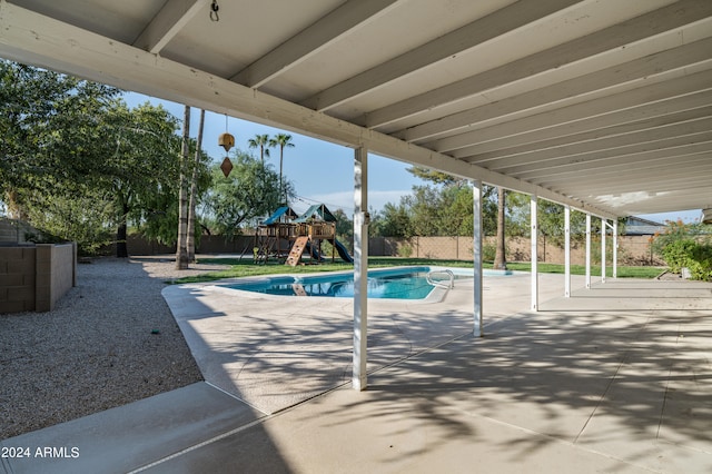 view of swimming pool featuring a playground and a patio area