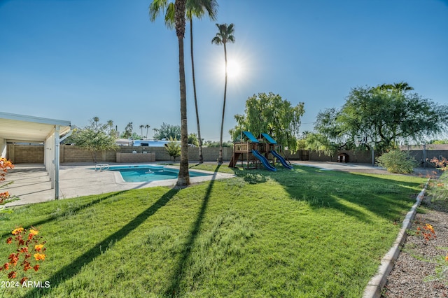 view of yard with a playground, a fenced in pool, and a patio area