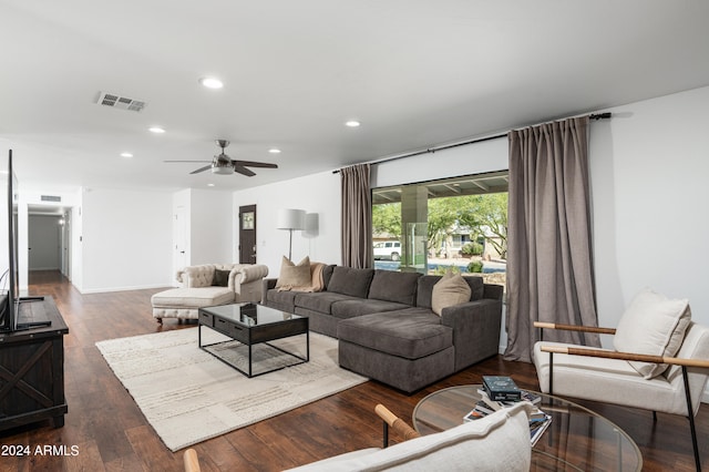 living room featuring dark wood-type flooring and ceiling fan