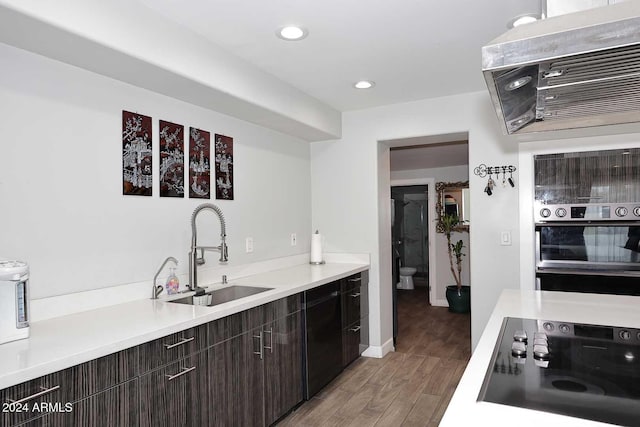 kitchen with stovetop, dark brown cabinetry, stainless steel double oven, and sink