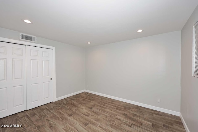 unfurnished bedroom with wood-type flooring and a closet