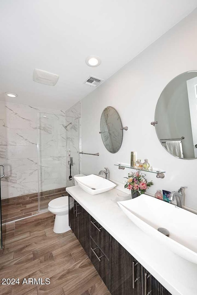 bathroom featuring vanity, toilet, and a shower with shower door