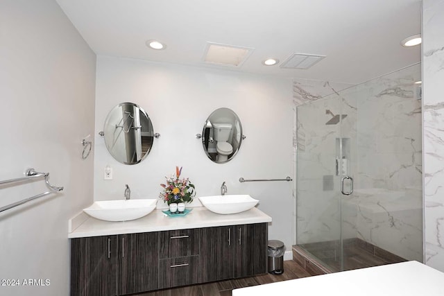 bathroom featuring a shower with door and vanity