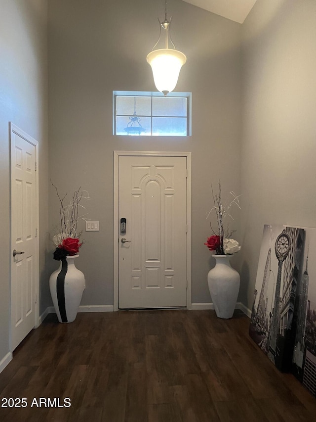 entrance foyer with high vaulted ceiling and dark hardwood / wood-style flooring