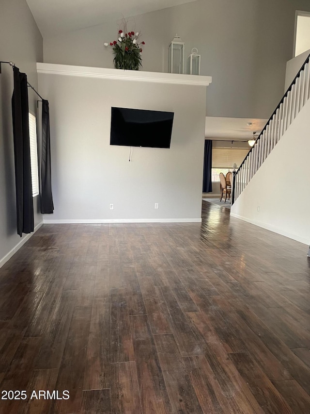 unfurnished living room with high vaulted ceiling and dark hardwood / wood-style floors