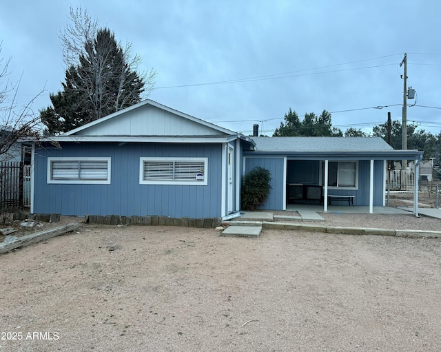 ranch-style house featuring a garage, fence, and a shingled roof