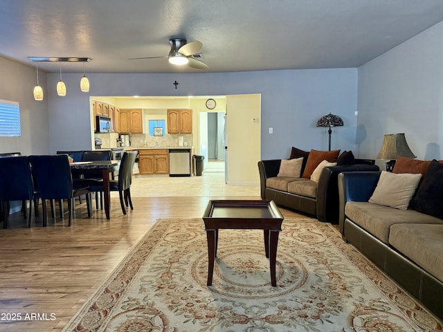 living area with light wood-type flooring and ceiling fan