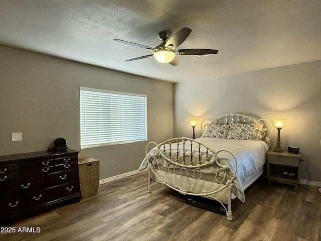 bedroom with a textured ceiling, ceiling fan, wood finished floors, and baseboards