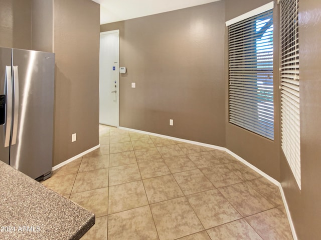 kitchen featuring light tile patterned floors and stainless steel refrigerator with ice dispenser