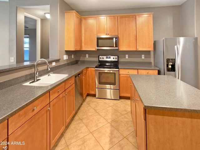 kitchen with a center island, sink, light tile patterned floors, and stainless steel appliances