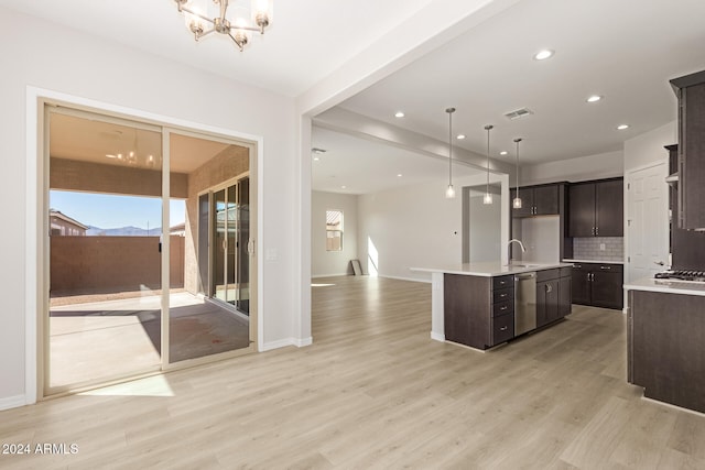 kitchen featuring light hardwood / wood-style flooring, hanging light fixtures, a kitchen island with sink, dark brown cabinets, and appliances with stainless steel finishes