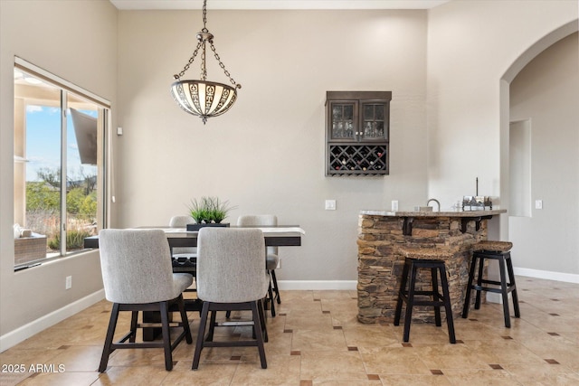 34096 N 87th Way, Scottsdale, AZ 85266 - dining room featuring indoor wet bar, arched walkways, baseboards, and a healthy amount of sunlight