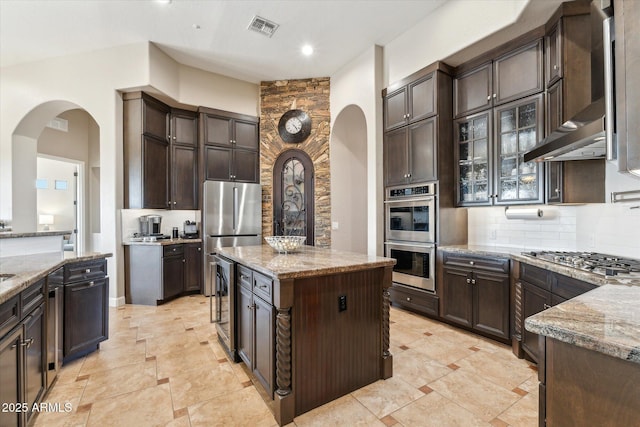 34096 N 87th Way, Scottsdale, AZ 85266 - kitchen with beverage cooler, arched walkways, light stone countertops, stainless steel appliances, and visible vents