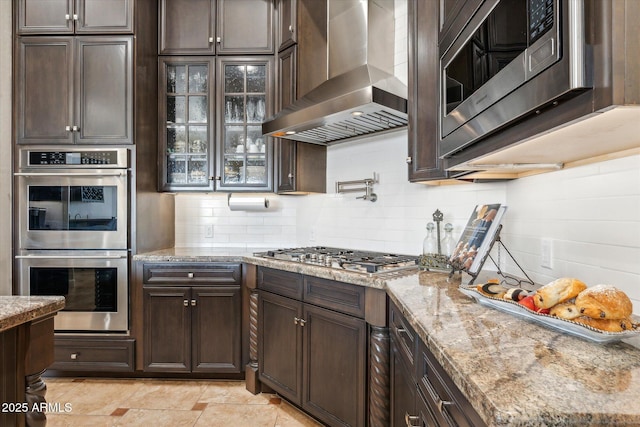 34096 N 87th Way, Scottsdale, AZ 85266 - kitchen featuring stainless steel appliances, dark brown cabinets, wall chimney exhaust hood, and decorative backsplash