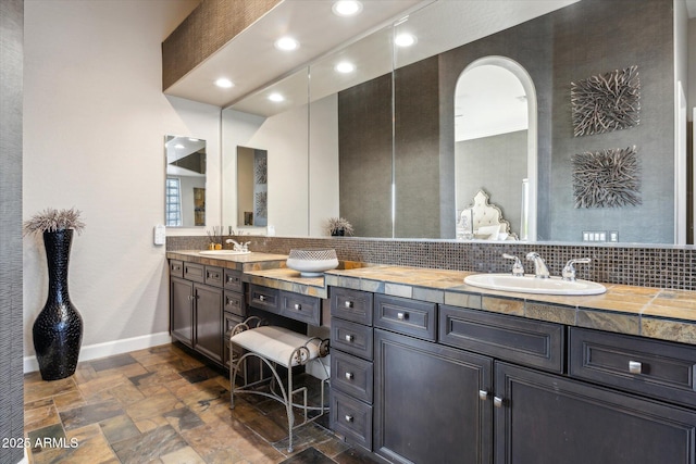 34096 N 87th Way, Scottsdale, AZ 85266 - bathroom with stone tile flooring, backsplash, baseboards, and a sink