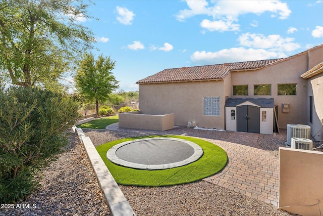 34096 N 87th Way, Scottsdale, AZ 85266 - rear view of property with a trampoline, a fenced backyard, stucco siding, a tiled roof, and central air condition unit