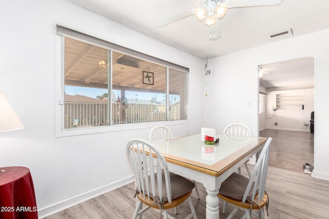 dining area featuring baseboards, visible vents, light wood-type flooring, and ceiling fan