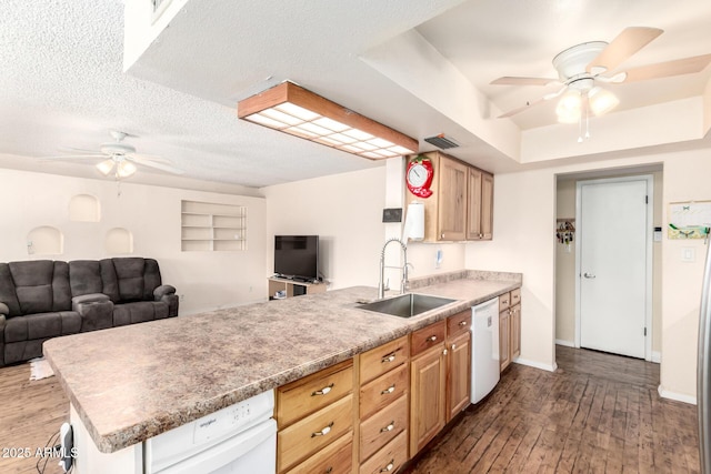 kitchen with visible vents, a peninsula, a sink, wood-type flooring, and open floor plan