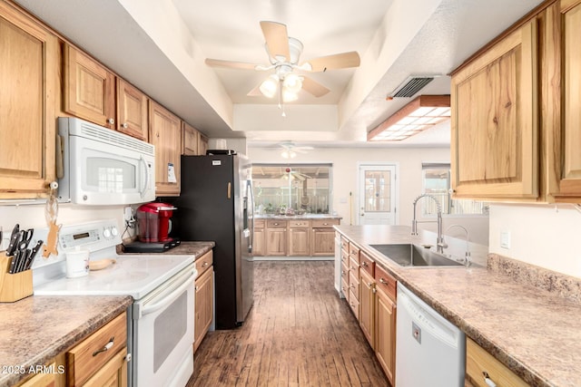 kitchen featuring visible vents, hardwood / wood-style flooring, a sink, white appliances, and a raised ceiling